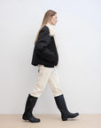 Side walking model view of Fireladyfur Day and Night Rider black down jacket with fox fur collar