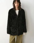 Model wearing the Castle Dusk black V-neck Toscana shearling coat, close front view