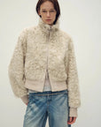 Model wearing the Curly Story light khaki sheep curly shearling bomber jacket, close front view