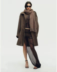 Woman styling a brown Firelady Fur shimmer Merino wool and cashmere fringe scarf
