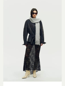 Woman wearing a grey Firelady Fur shimmer Merino wool and cashmere fringe scarf