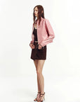 Pink lambskin cropped leather moto jacket side view on model