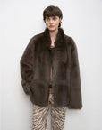 Woman wearing the Heartbeat Mark dark brown Toscana shearling coat, front view