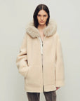 Model wearing Hokkaido Melody off-white long hooded Merino shearling coat