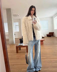 Woman styling the Icelandic Bell Sound classic white coat, full-length mirror view