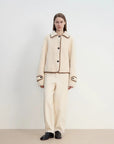 Off-white Merino shearling jacket styled with matching trousers, full-length front view