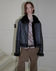 Woman modeling the black Toscana shearling motorcycle jacket indoors