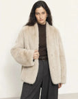 Woman wearing the Night in Paris camel Toscana shearling V-neck coat, front view