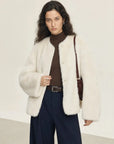 Woman wearing the Night in Paris off-white Toscana shearling coat, front view