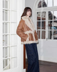 Woman styling the Oppenheimer brown Toscana shearling coat indoors