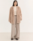 Model wearing the Peach Oolong misty pink Toscana sheepskin winter coat, full-length view