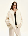 Woman wearing the Quiet Warmth ivory Merino shearling jacket, front view
