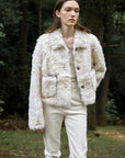 Model styling the Rachel off-white two-tone curly wool shearling coat outdoors