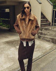 Model styling the Silky Cocoa amber brown shearling coat outdoors