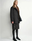 THE ARTM women's Black detachable fur collar nylon down parka side view on model