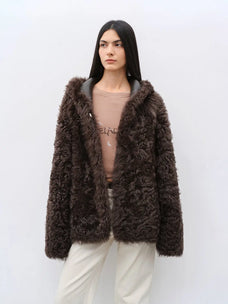 Woman wearing the Winter Snow brown hooded Toscana shearling coat, front view