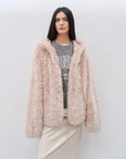 Woman wearing the Winter Snow dirty pink hooded Toscana shearling coat, front view