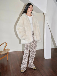 Woman styling the Winter Snow off-white Toscana shearling coat indoors