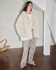 Woman styling the Winter Snow off-white Toscana shearling coat indoors