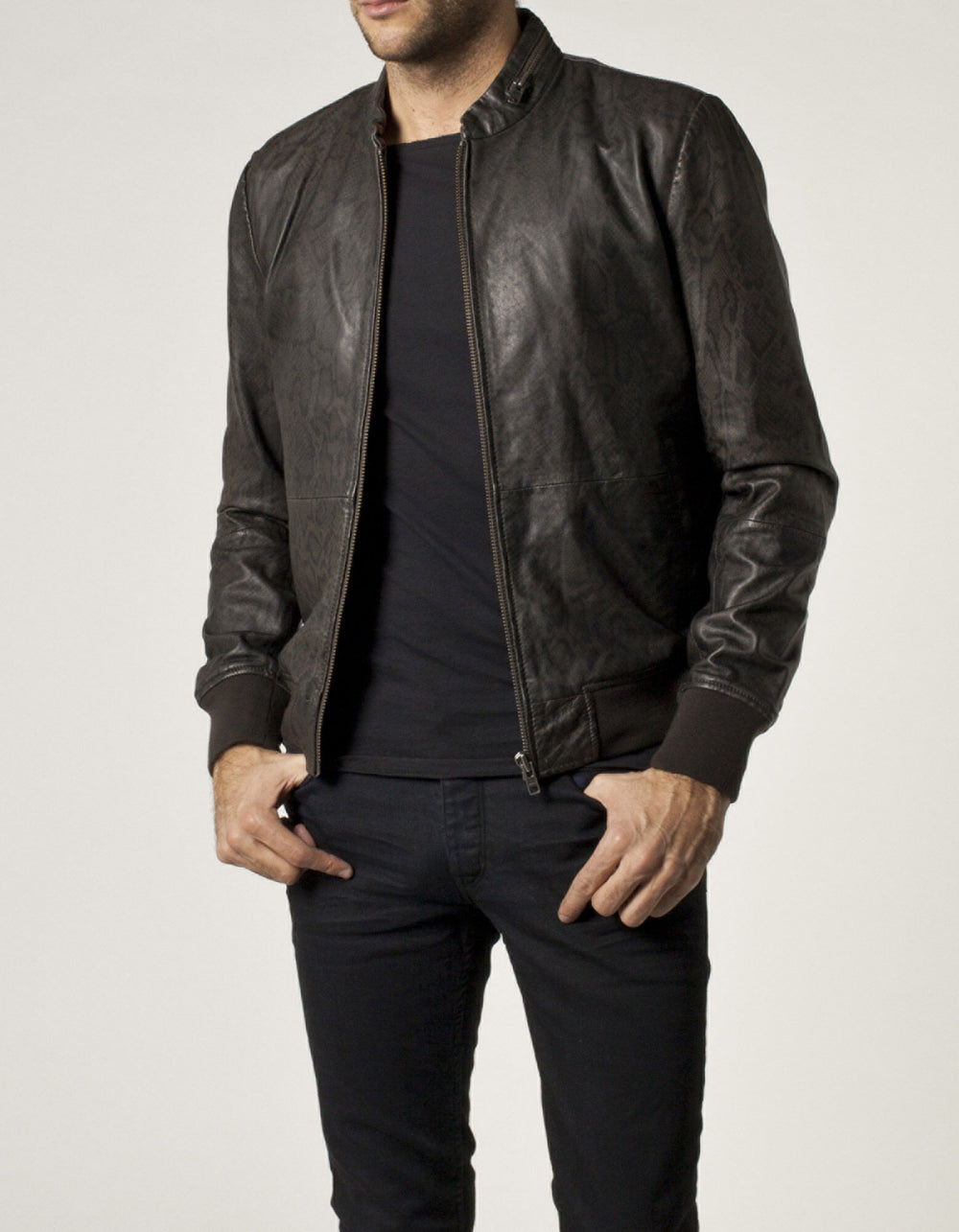 IKKS jacket worn open: dark snake-like printed pattern beside front zipper, stand collar, sleeves and ribbed hem.
