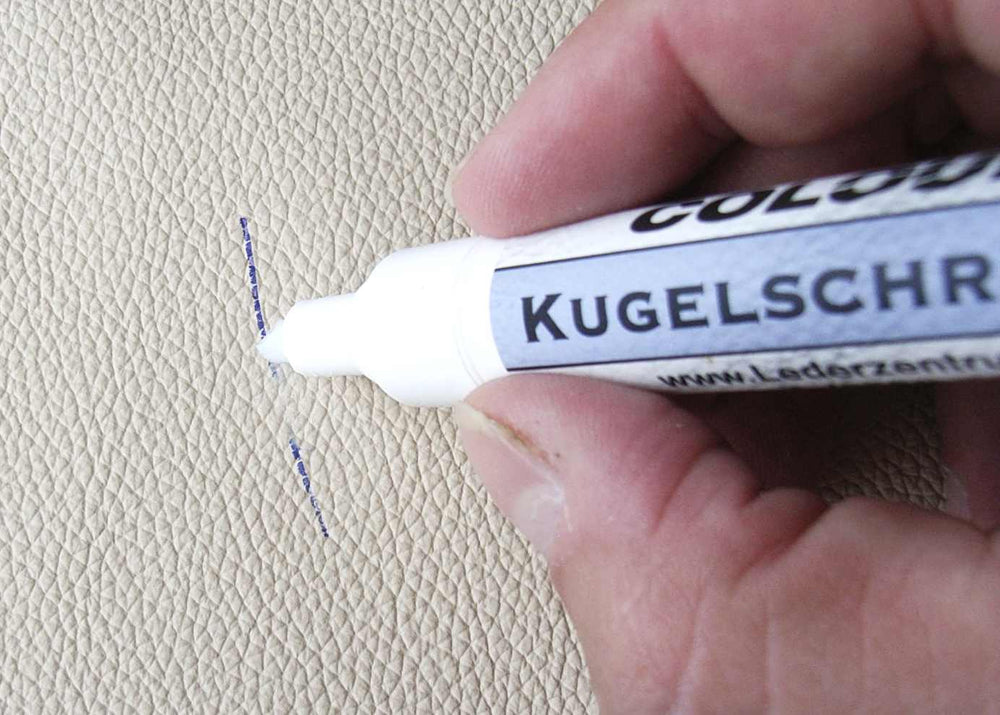 a remover tip at a pen line. Follow the exact product’s leather-finish restrictions; the photo is not a jacket treatment instruction.