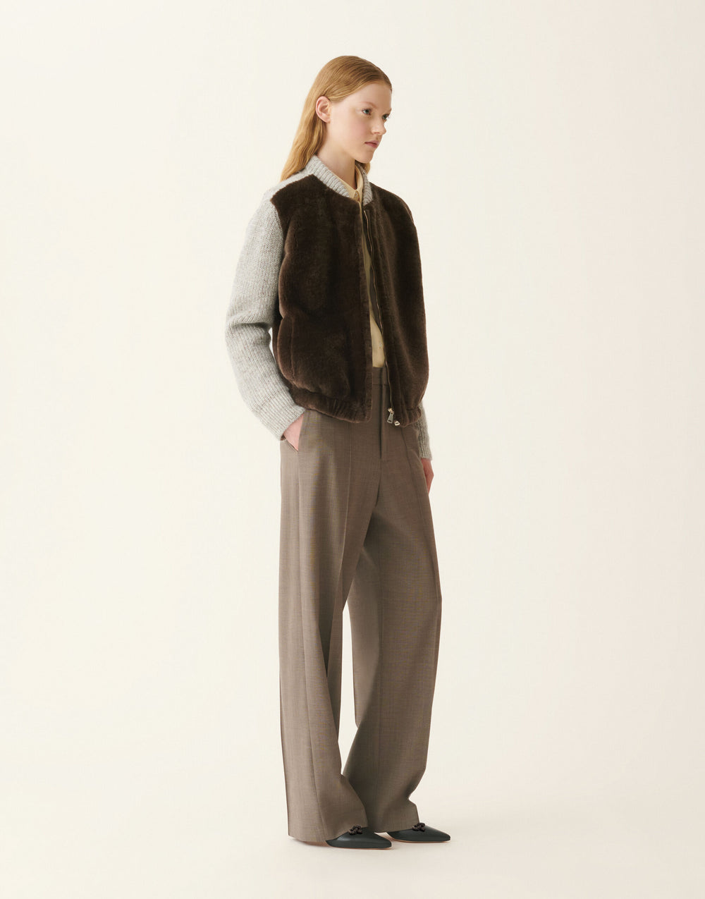 Brown shearling-front jacket with contrasting light knit sleeves.