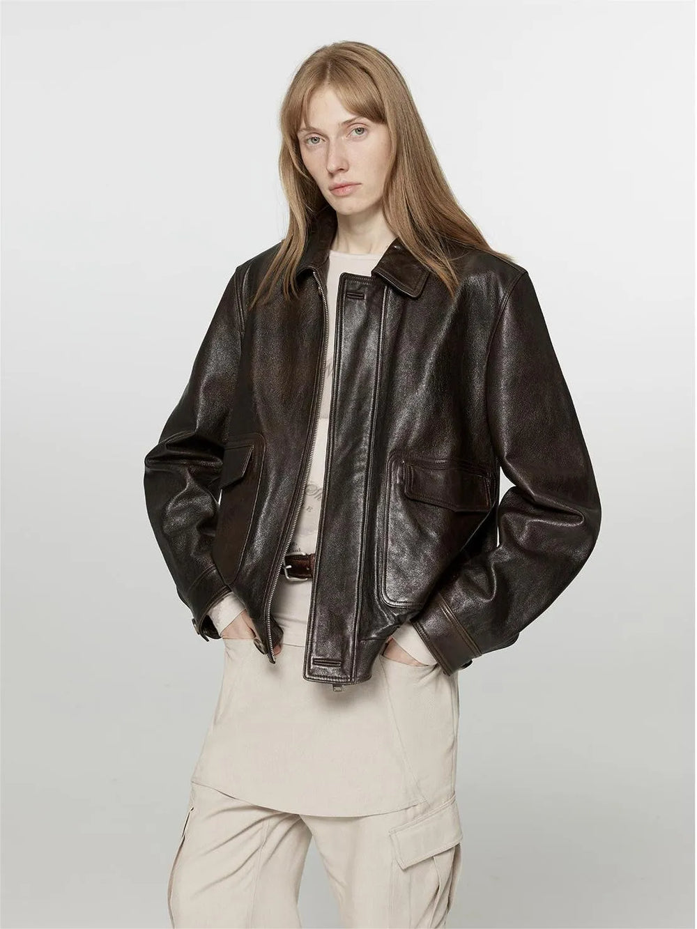 Brown shirt-collar jacket worn open over a light top.