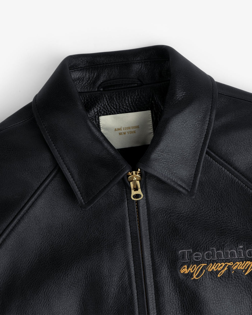 Upper zipper slider at the collar of a black ALD Technics leather jacket