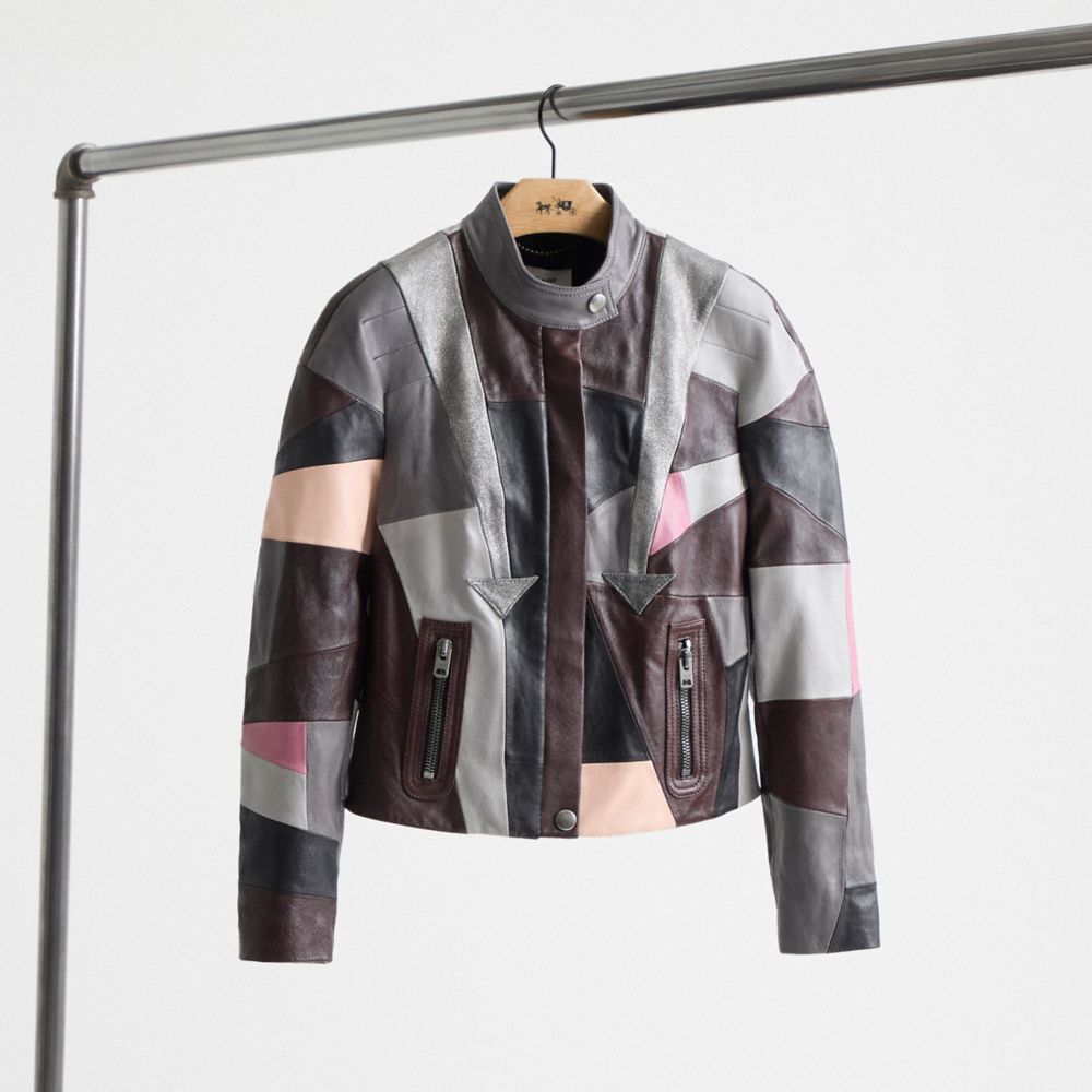 Coach racer jacket with contrasting gray, brown, cream and pink leather panels