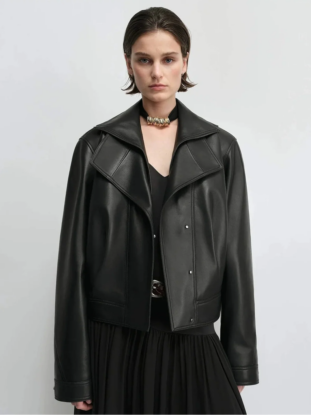 Black asymmetric women's biker jacket showing diagonal closure and open lapels