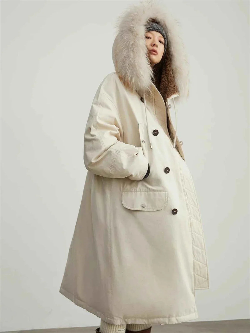 Manchester parka worn by a model with the pale fur-trim hood raised beside the face