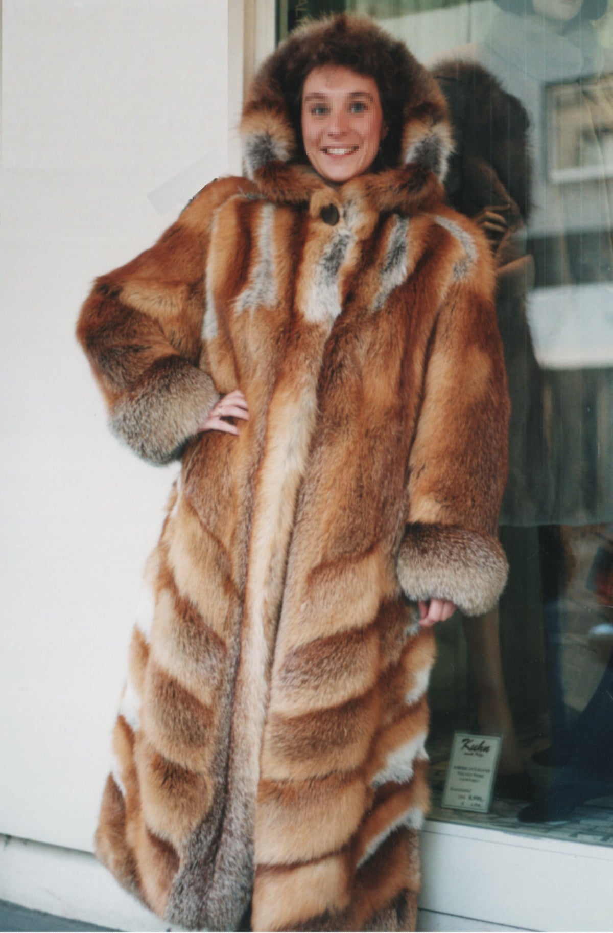 Woman wearing a reddish-brown hooded red-fox fur coat outside a shop, Germany 1999; documentary material reference, not the story's character