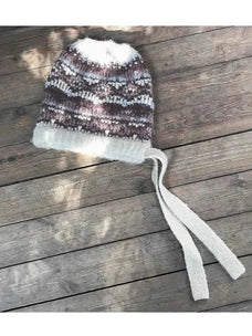 Women's khaki jacquard wool knit hat with tassel on rustic wood