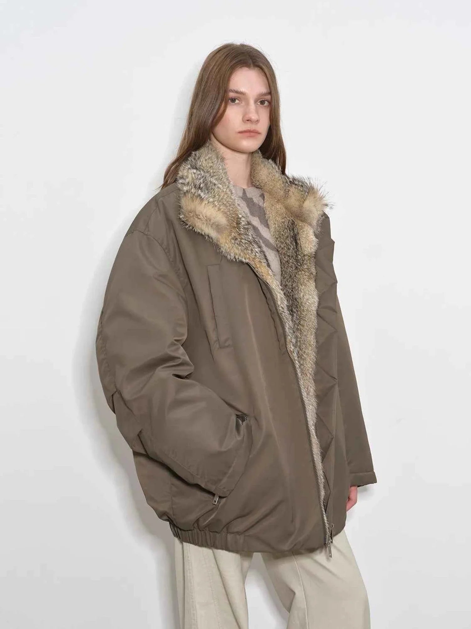 Side view of model wearing Fireladyfur Travel Notes sand green down jacket with fluffy fox fur collar