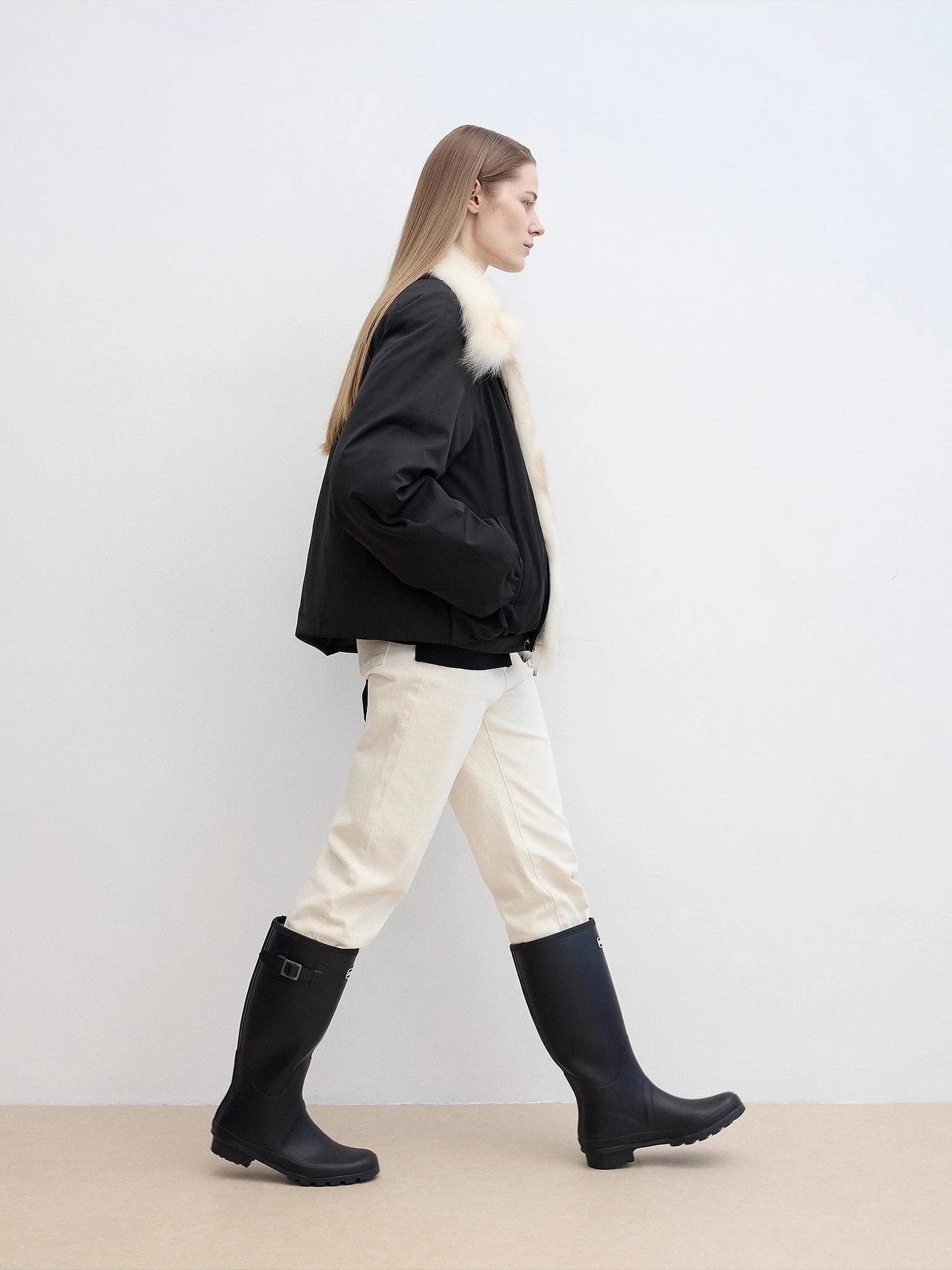 Side walking model view of Fireladyfur Day and Night Rider black down jacket with fox fur collar