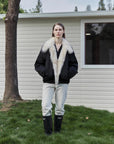Outdoor model view of Fireladyfur Day and Night Rider black down jacket with contrasting fox fur collar