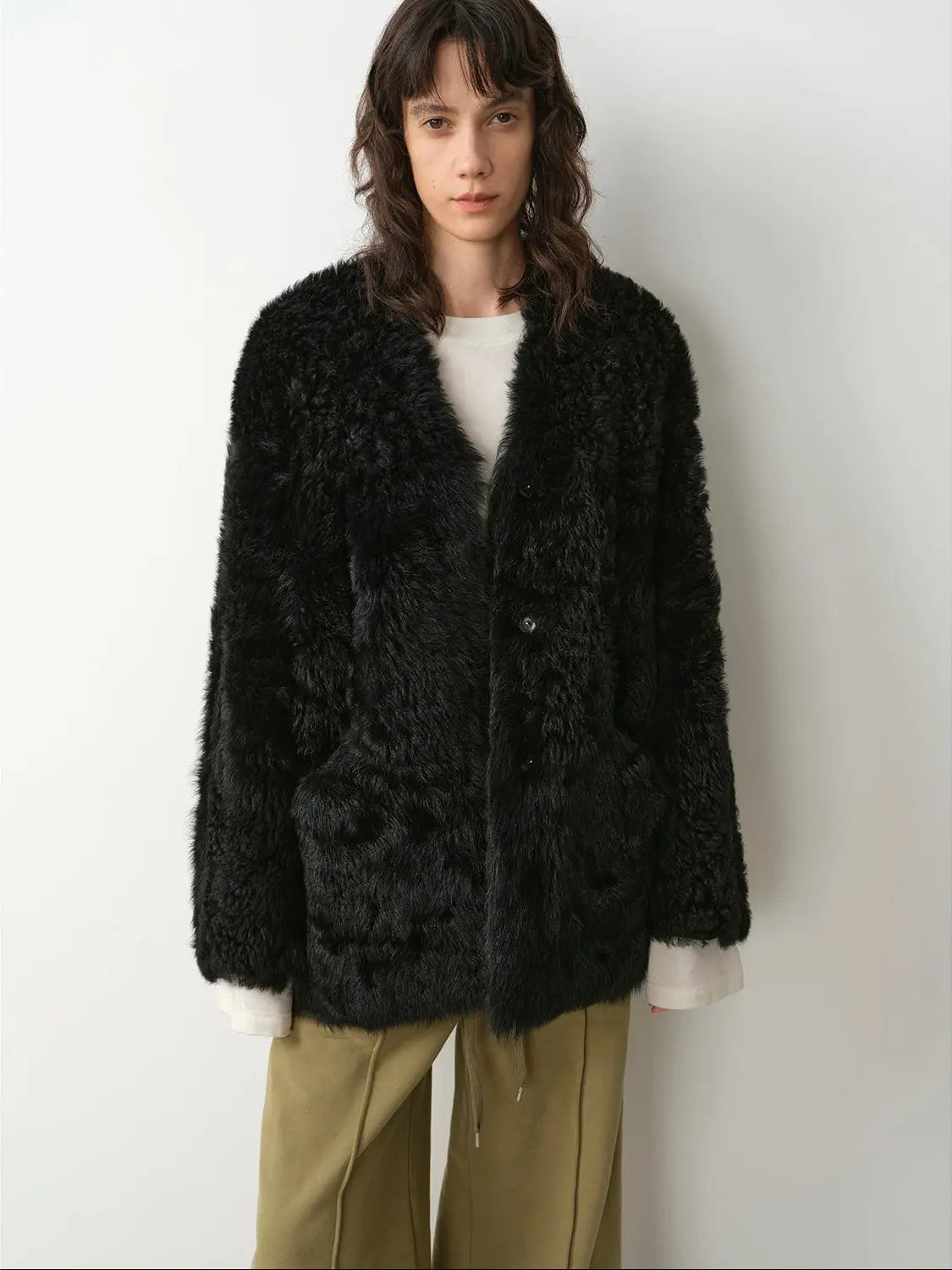 Model wearing the Castle Dusk black V-neck Toscana shearling coat, close front view