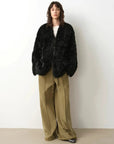 Model wearing the Castle Dusk black V-neck Toscana shearling coat, full-length view