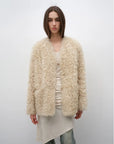 Model wearing the Castle Dusk natural ivory V-neck Toscana shearling coat, front view