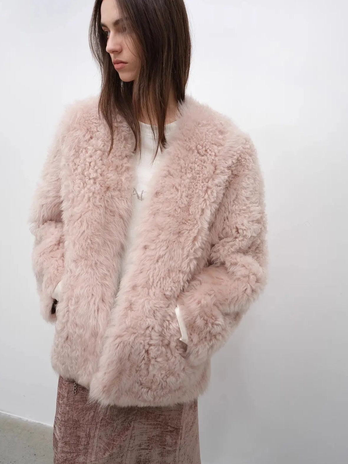 Model styling the Castle Dusk pink V-neck Toscana shearling coat, close lifestyle view