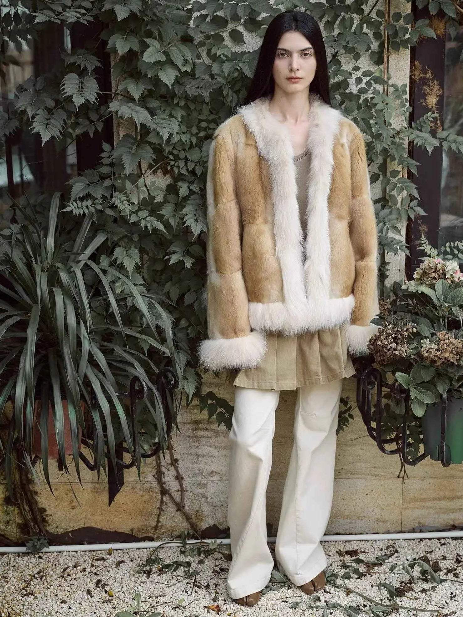 Model wearing Casual Gene Yellow Apricot fur coat in a garden setting