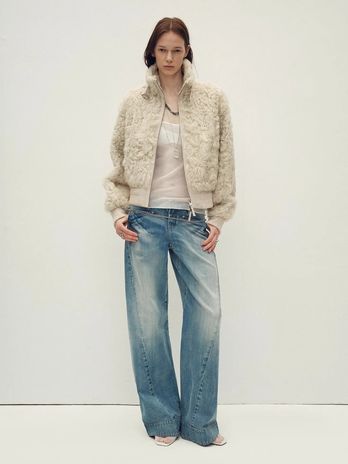 Model wearing the Curly Story light khaki sheep curly shearling bomber jacket, full-length view
