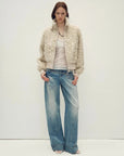 Model wearing the Curly Story light khaki sheep curly shearling bomber jacket, full-length view