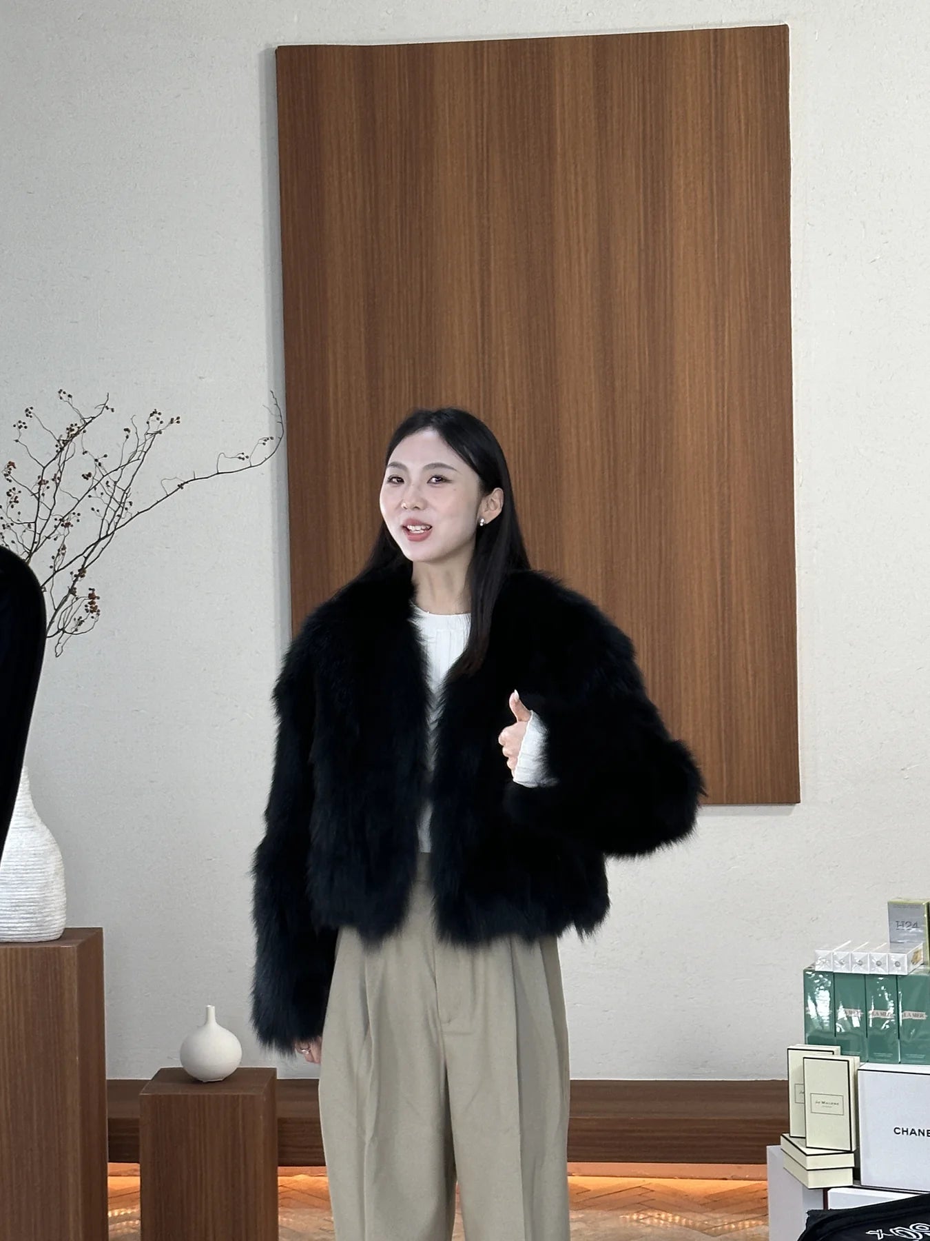 Short black fur jacket styled with a pale trouser base