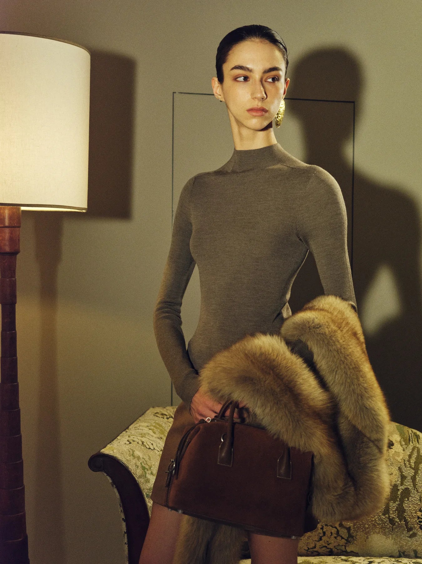 Evening outfit with fur texture and a calm lamp-lit column