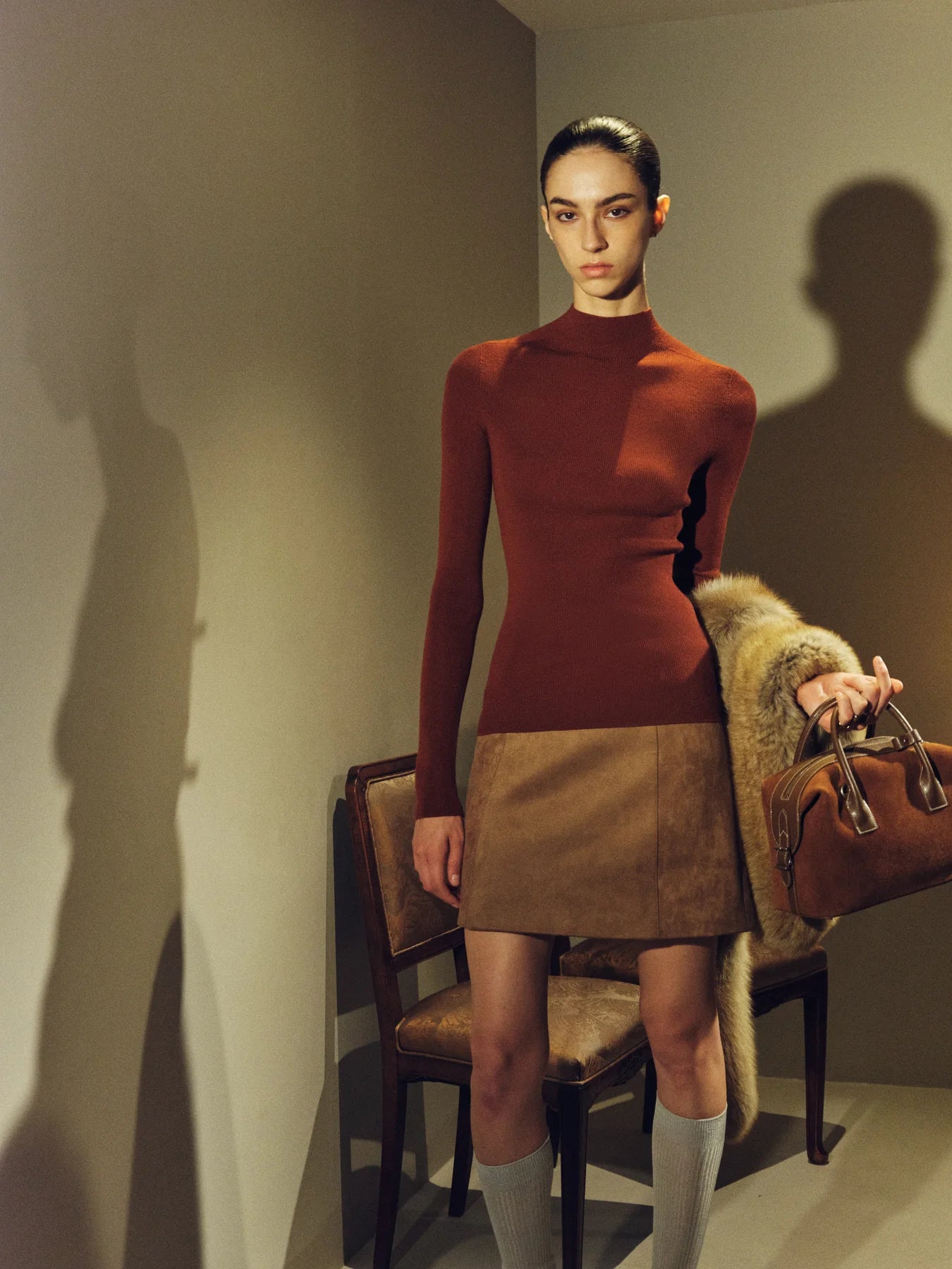 Rust dress and fur texture used to show evening color restraint