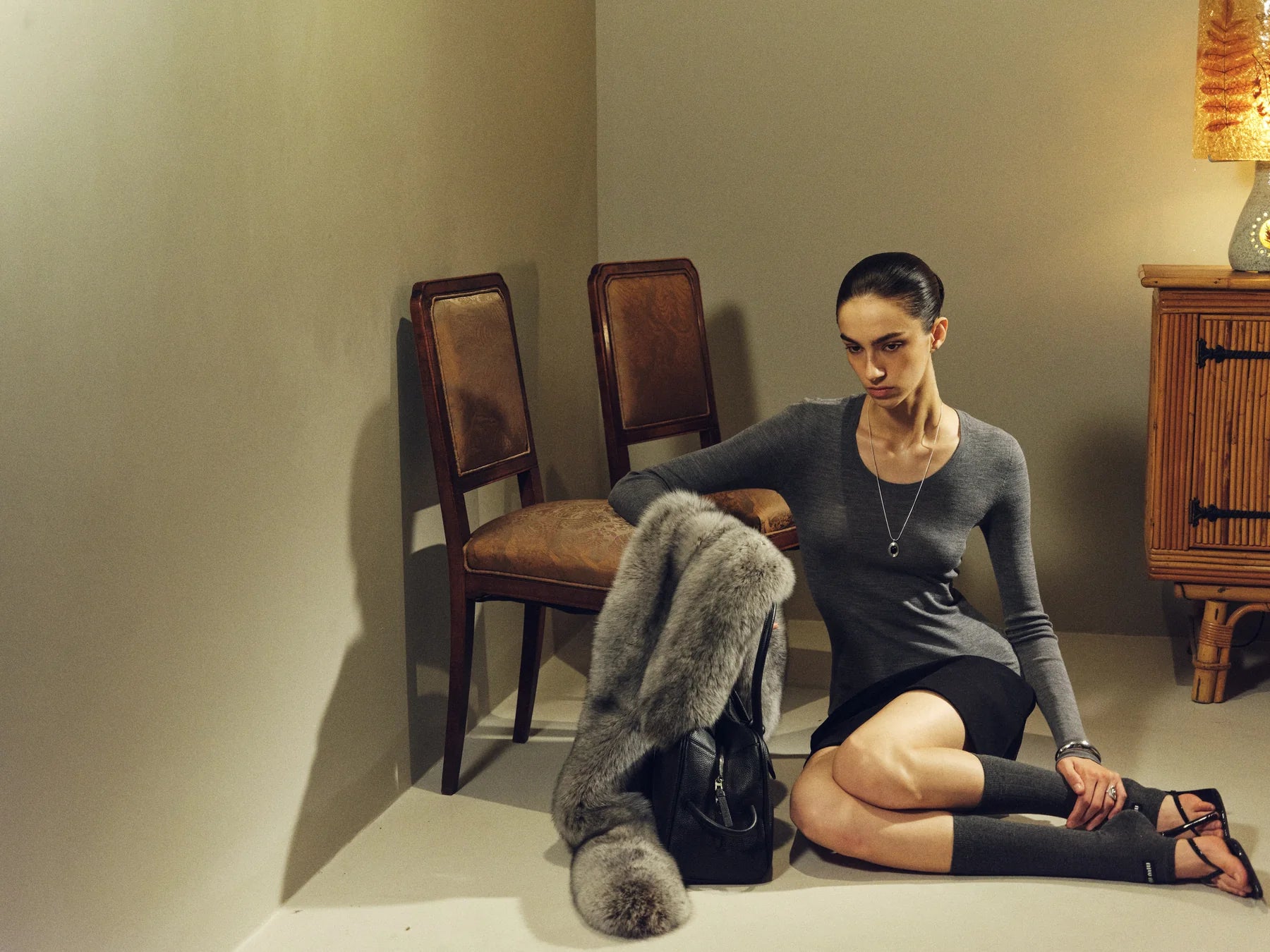 Seated outfit showing boot shape and coat volume together