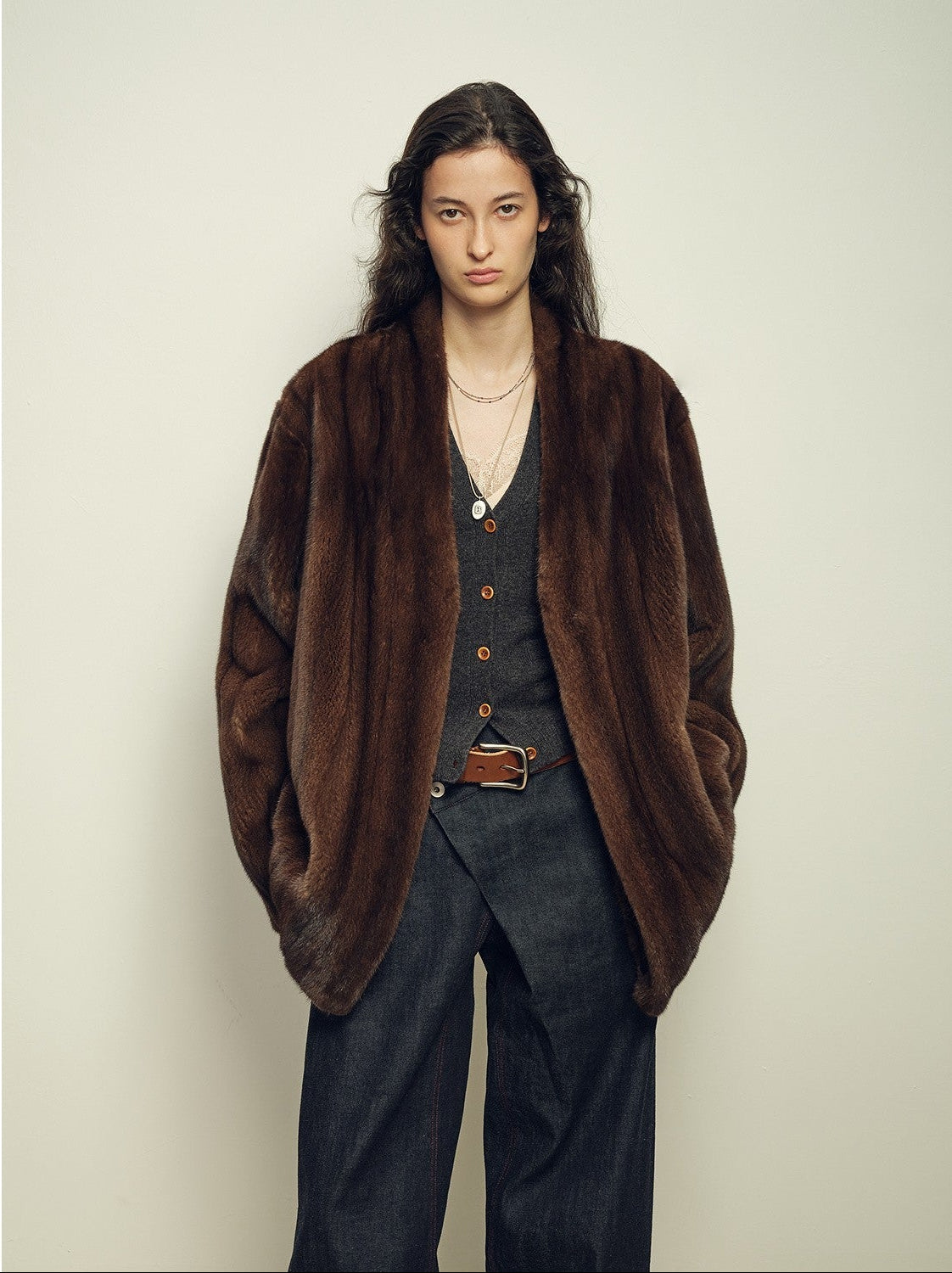 Dark mink fur coat styled with denim for a grounded wardrobe mood