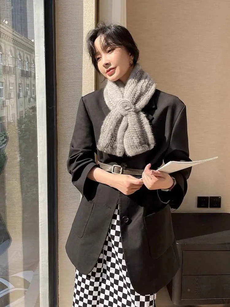 Woman wearing a silver gray mink flower scarf with a black blazer