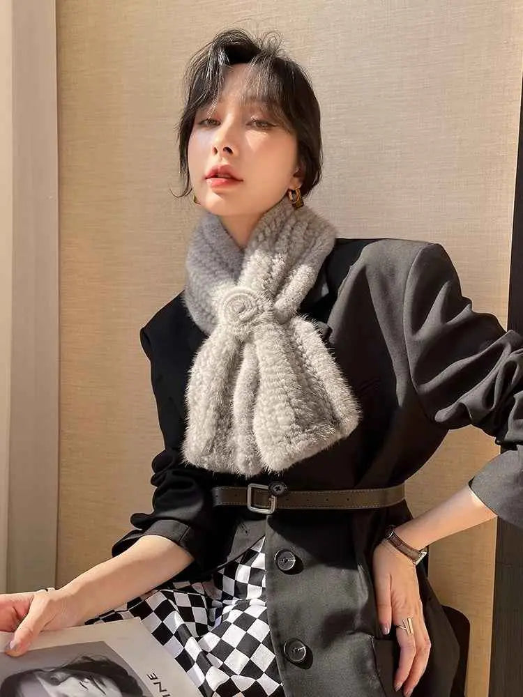 Woman styling a silver gray mink flower scarf in natural light